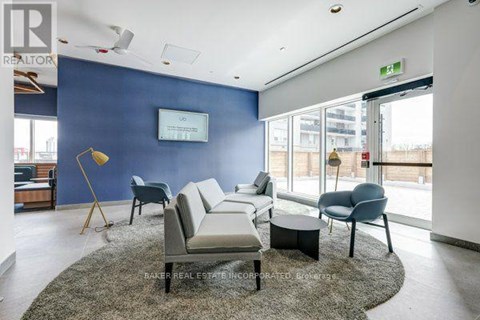 A living room with a grey rug and a white sofa.