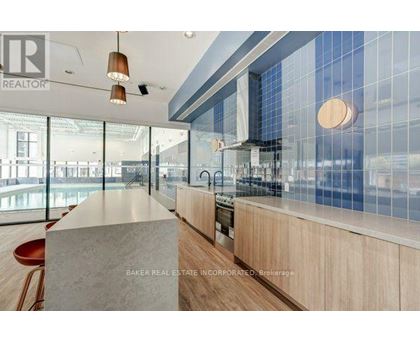A modern kitchen with a large island and pendant lights.