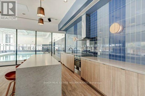 A modern kitchen with a large island and pendant lights.