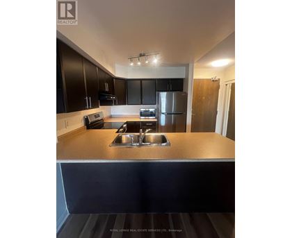 A kitchen with a stainless steel refrigerator and a sink.