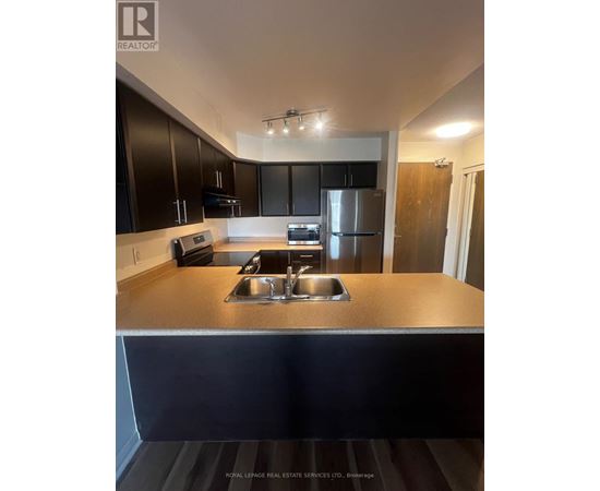 A kitchen with a stainless steel refrigerator and a sink.