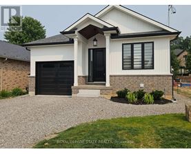 A white house with a black door and windows is for sale.