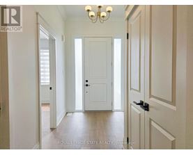 A hallway with a white door and a chandelier.