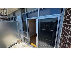 A view from the balcony of a building with a glass door and a brick wall.