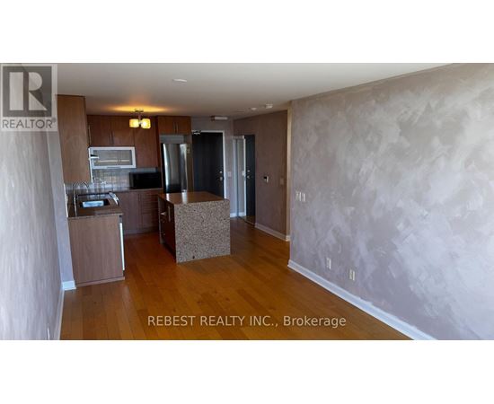 A kitchen area with wooden floors and a countertop.
