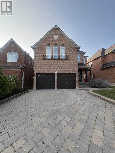 A brick house with a driveway in front.