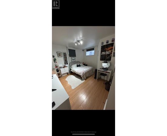 A bedroom with a bed, desk, and a poster on the wall.