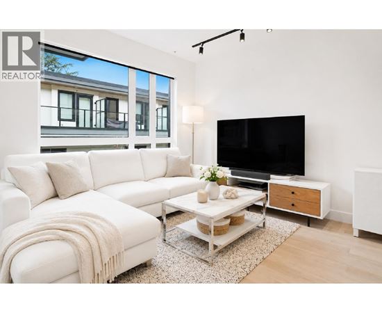 A living room with a white couch and a flat screen TV.