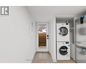 A laundry room with a washer and dryer stacked on top of each other.