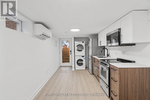 A kitchen with white cabinets and a microwave above the stove.