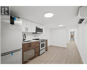 A kitchen with a refrigerator, microwave, oven and cabinets.