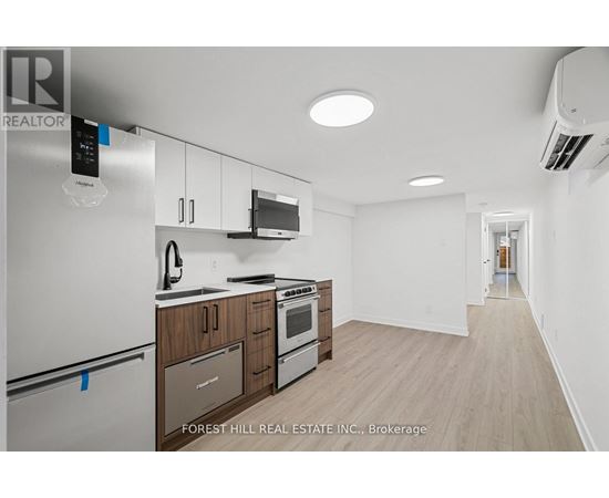 A kitchen with a refrigerator, microwave, oven and cabinets.