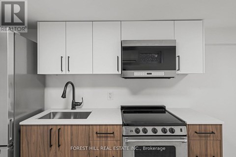 A kitchen with a sink, stove and cabinets.