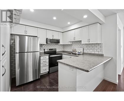 A kitchen with white cabinets and a stainless steel refrigerator.