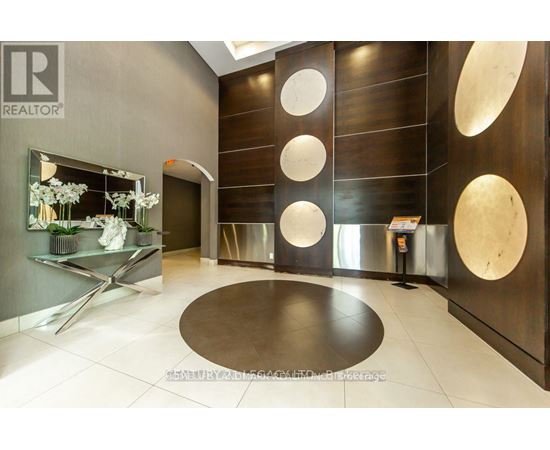 A modern office lobby with a glass wall and a wooden panelled wall.