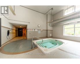 A large indoor swimming pool with a walk-in spa area.