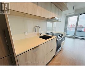 A kitchen with wooden cabinets and a black stove top oven.