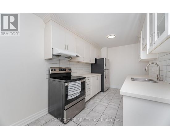 A kitchen with white cabinets and black appliances.