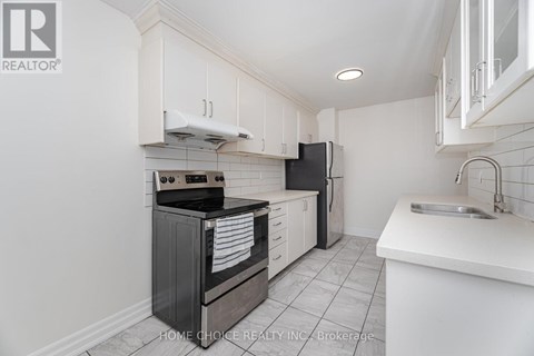 A kitchen with white cabinets and black appliances.