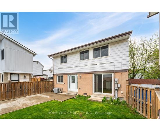 A house with a white exterior and a brown fence is for sale.