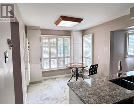 A kitchen with a table and chairs in front of a window.