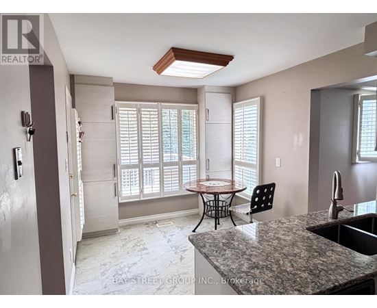 A kitchen with a table and chairs in front of a window.