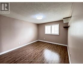 A room with a window and wooden flooring.