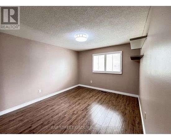 A room with a window and wooden flooring.