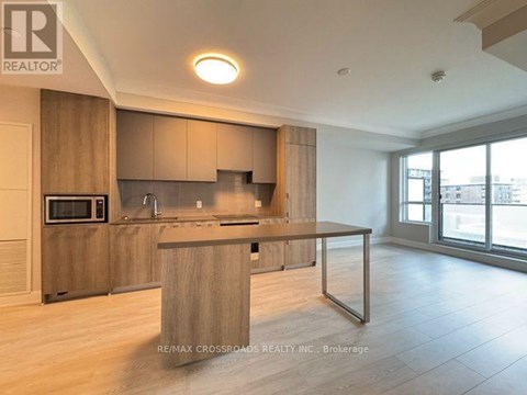 A modern kitchen with wooden cabinets and a large island.