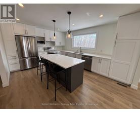 A modern kitchen with a central island and stainless steel appliances.