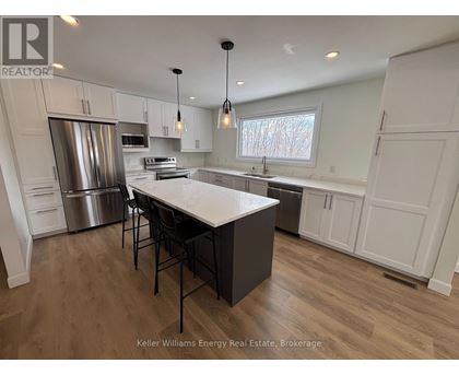 A modern kitchen with a central island and stainless steel appliances.