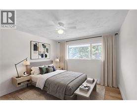 A bedroom with a bed, nightstand, and window.