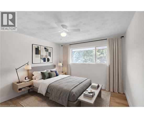 A bedroom with a bed, nightstand, and window.