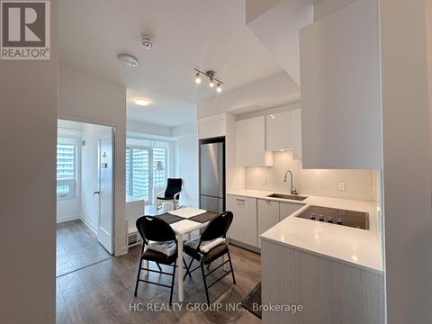 A modern kitchen with white cabinets and a dining table with four chairs.