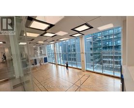 A spacious office with glass walls and wooden floors.