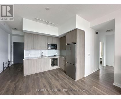 A modern kitchen with wooden cabinets and stainless steel appliances.