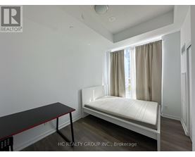 A bedroom with a bed, table, and window.