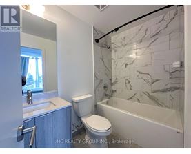 A bathroom with a marble tile shower and toilet.