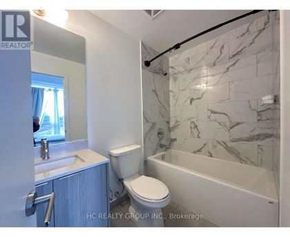A bathroom with a marble tile shower and toilet.
