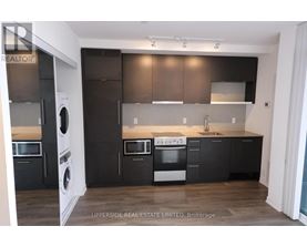 A modern kitchen with dark brown cabinets and stainless steel appliances.