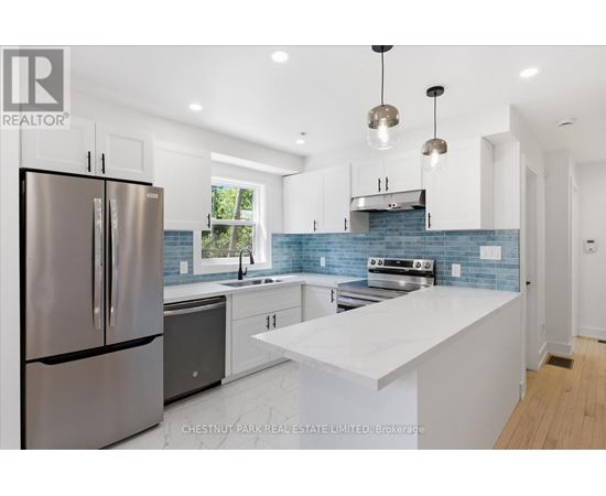 A modern kitchen with a stainless steel refrigerator and a white countertop.