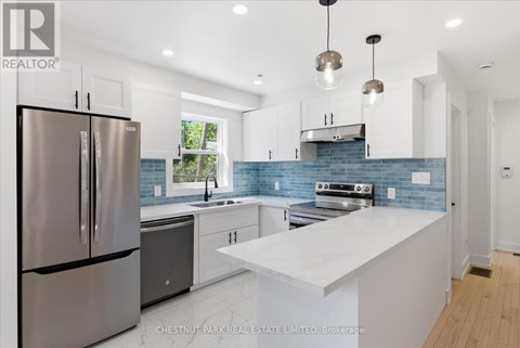 A modern kitchen with a stainless steel refrigerator and a white countertop.
