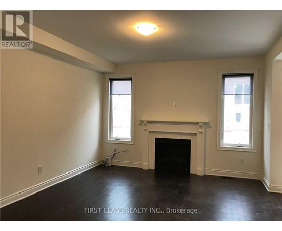 A room with a fireplace and two windows.