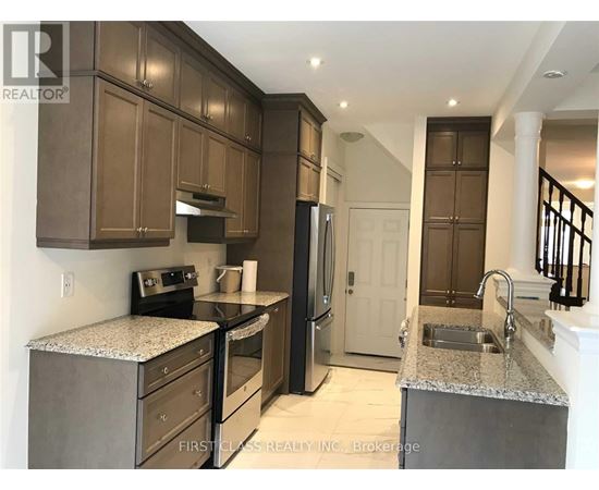 A kitchen with brown cabinets and a granite countertop.