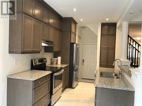 A kitchen with brown cabinets and a granite countertop.