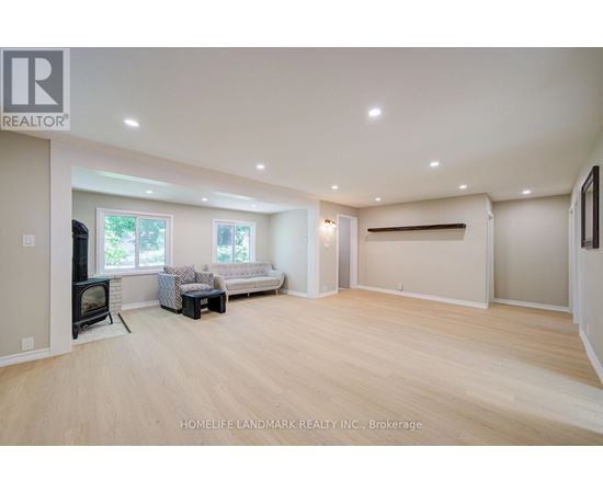A spacious living room with wood flooring and a fireplace.