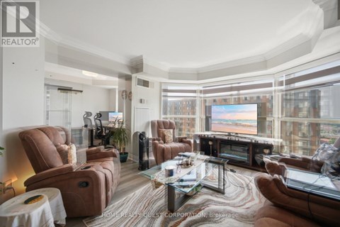 A living room with brown leather furniture and a large window overlooking a cityscape.