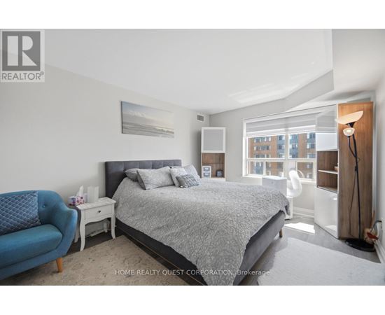 A bedroom with a large bed and a blue chair.