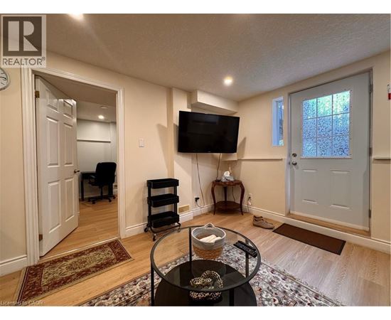 A living room with a TV, a chair, and a table with a bowl on it.