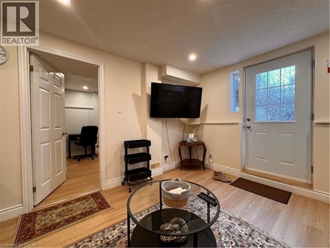 A living room with a TV, a chair, and a table with a bowl on it.